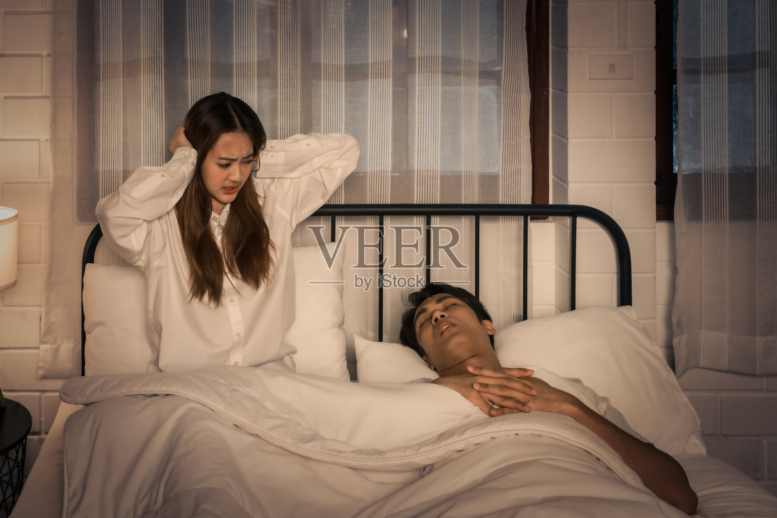 女人因夜里大声打鼾而苦恼照片摄影图片