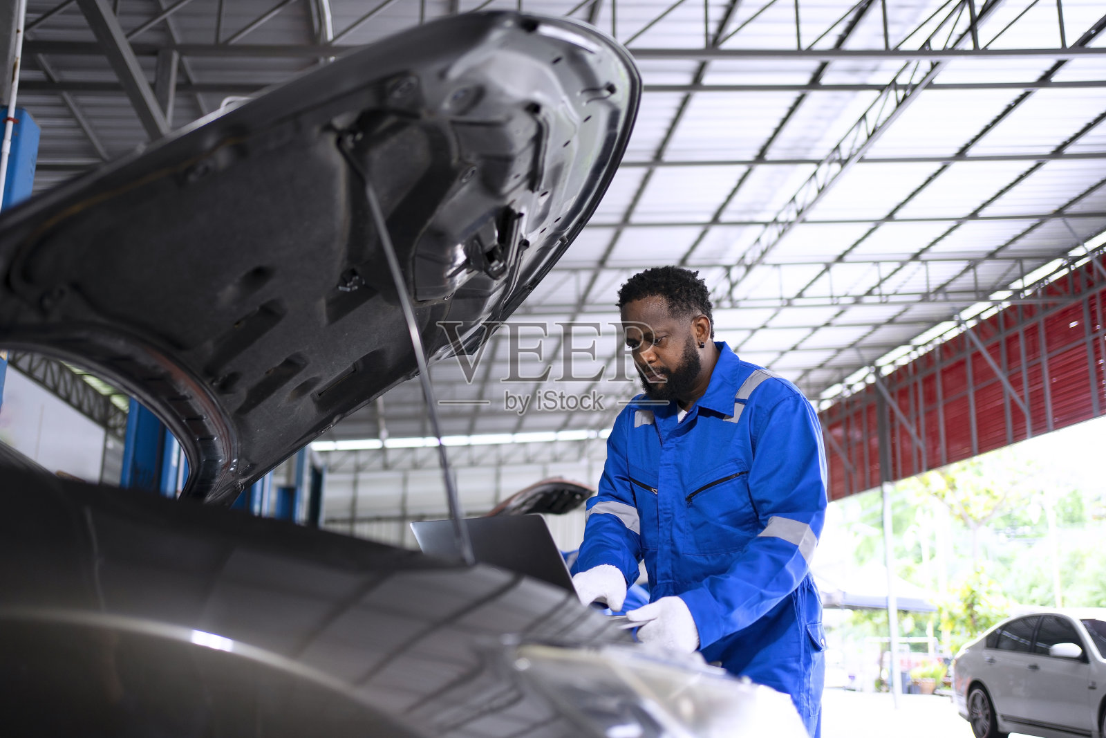 在汽车修理厂做机械师工作。照片摄影图片