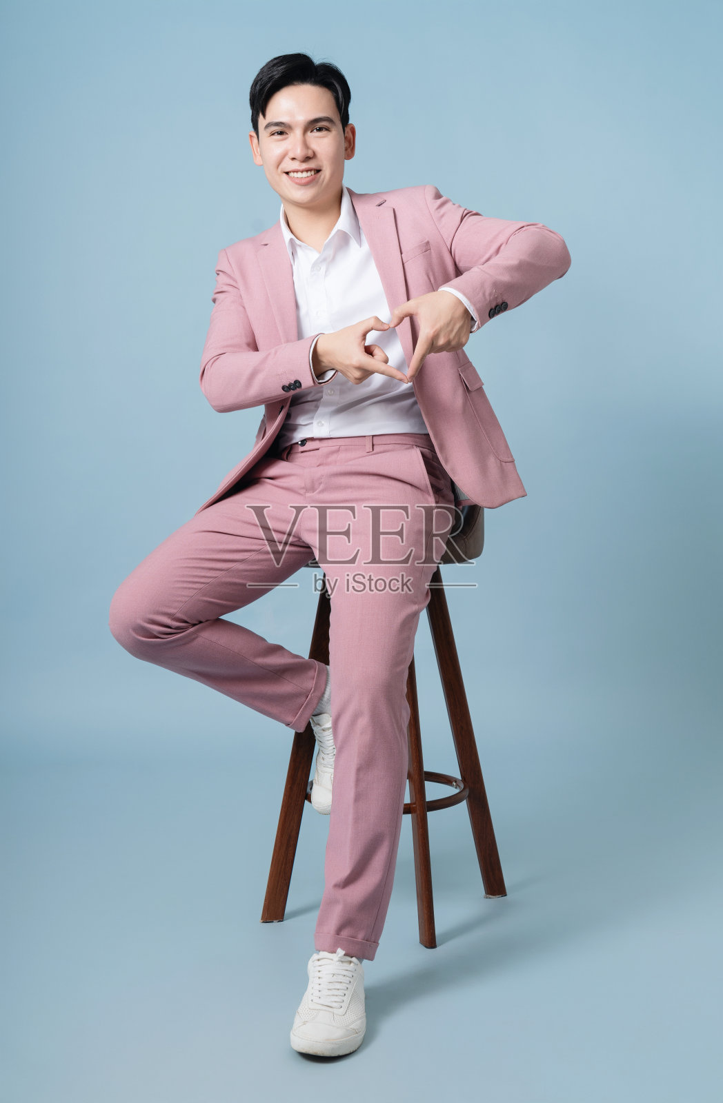 背景是穿着粉红色西装的年轻亚洲商人的照片照片摄影图片