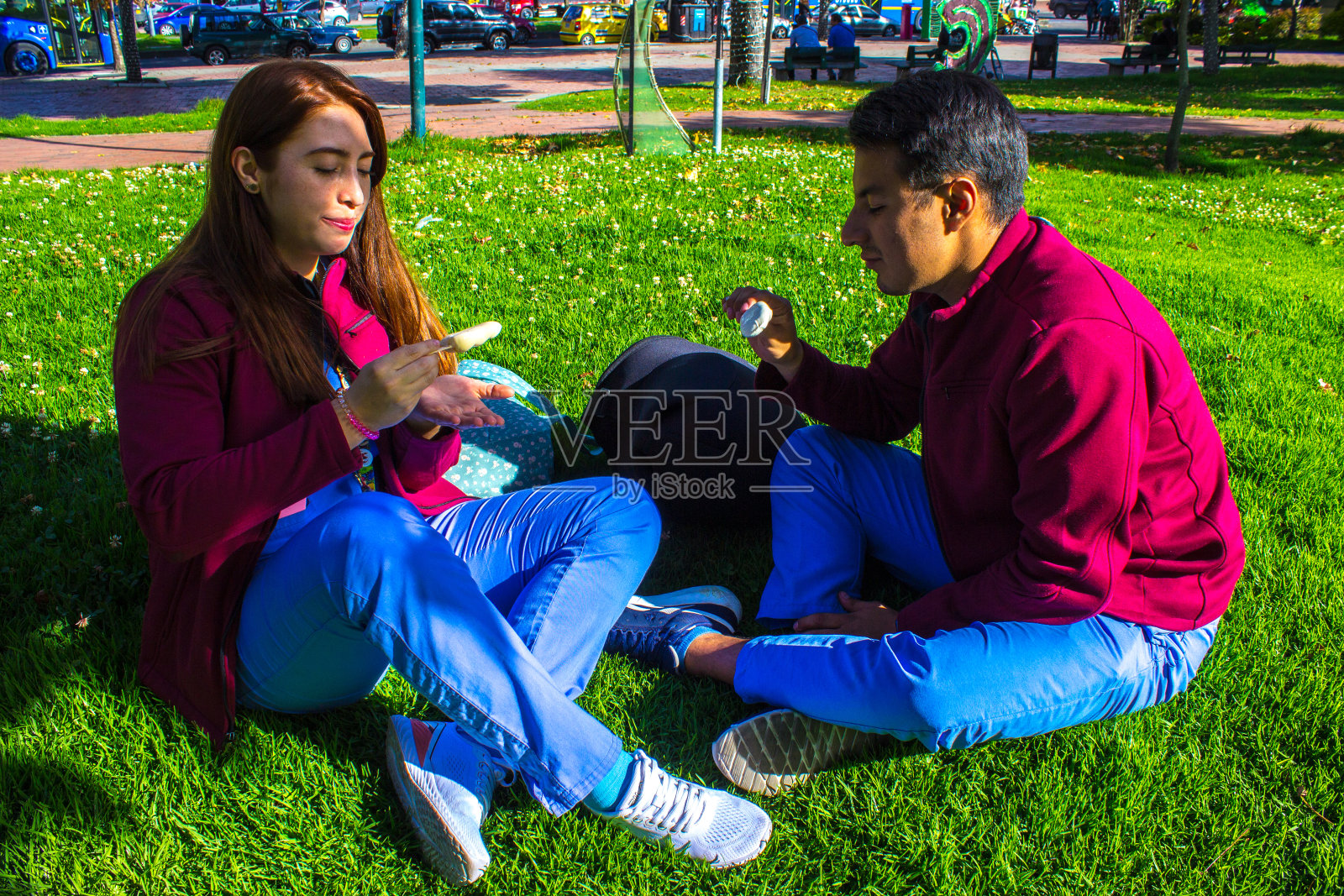 情侣们在公园里微笑着吃冰激凌照片摄影图片