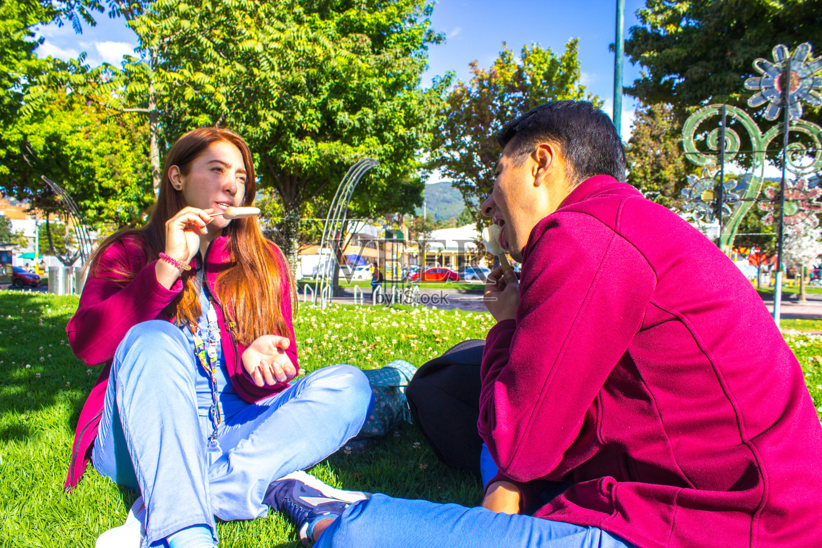 情侣们在公园里微笑着吃冰激凌照片摄影图片