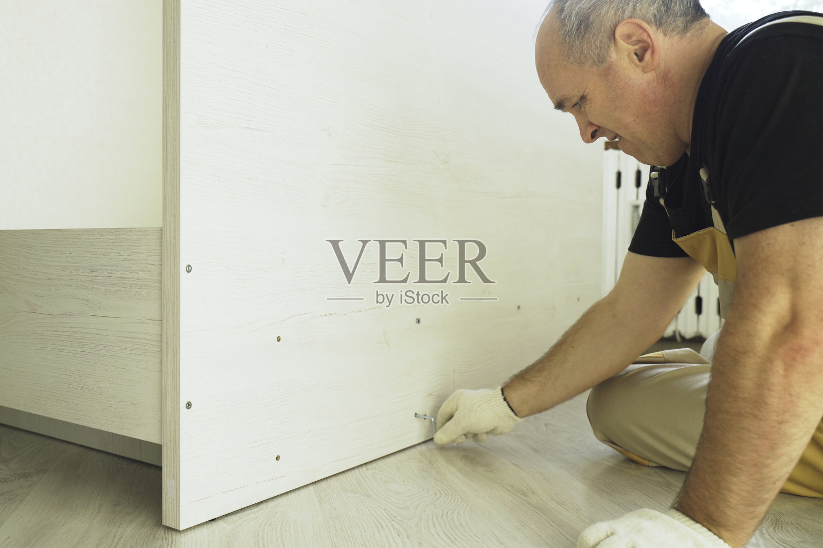 一名工人正在用确认书固定床的部件。照片摄影图片