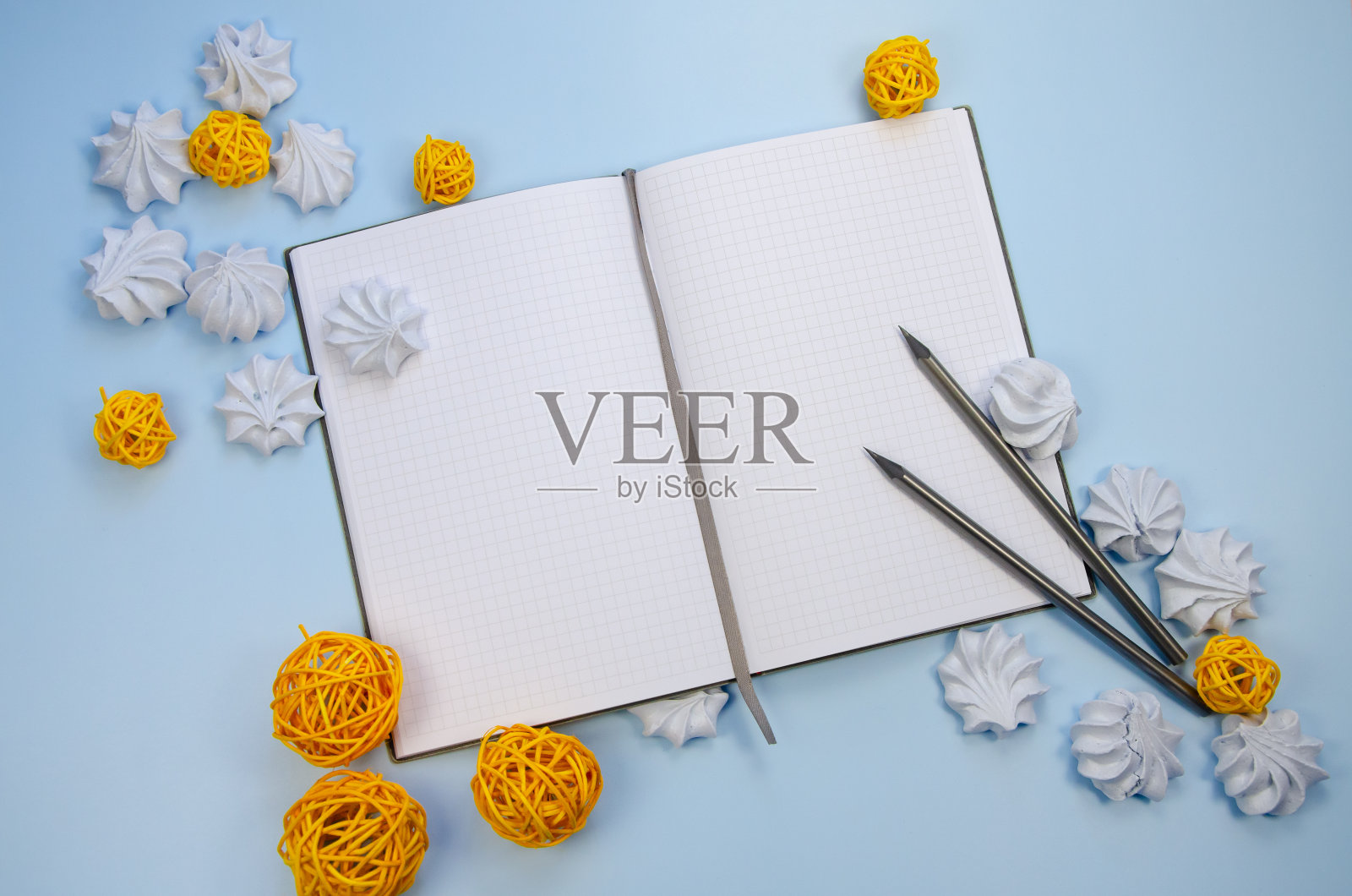 马卡龙，空白笔记本，模拟空白页，深色铅笔和黄色装饰蓝色背景的模板冬季构图新年计划愿望清单，待办事项清单，冬季食谱照片摄影图片