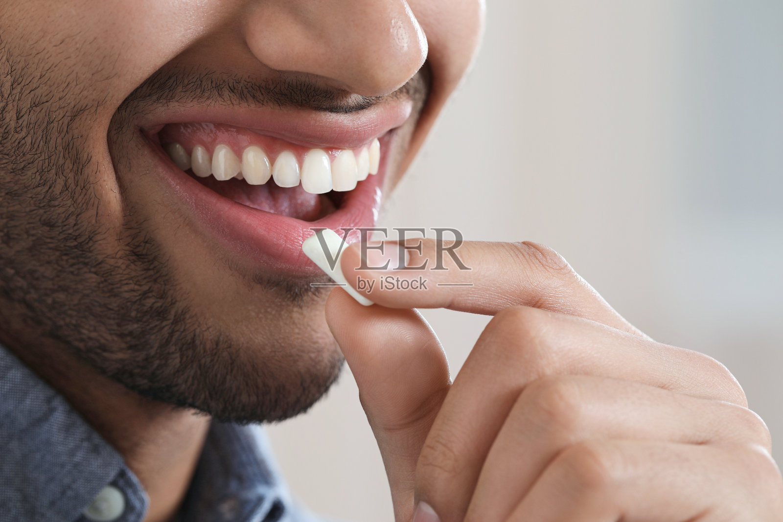 一个嚼着口香糖的男人，背景模糊，特写照片摄影图片