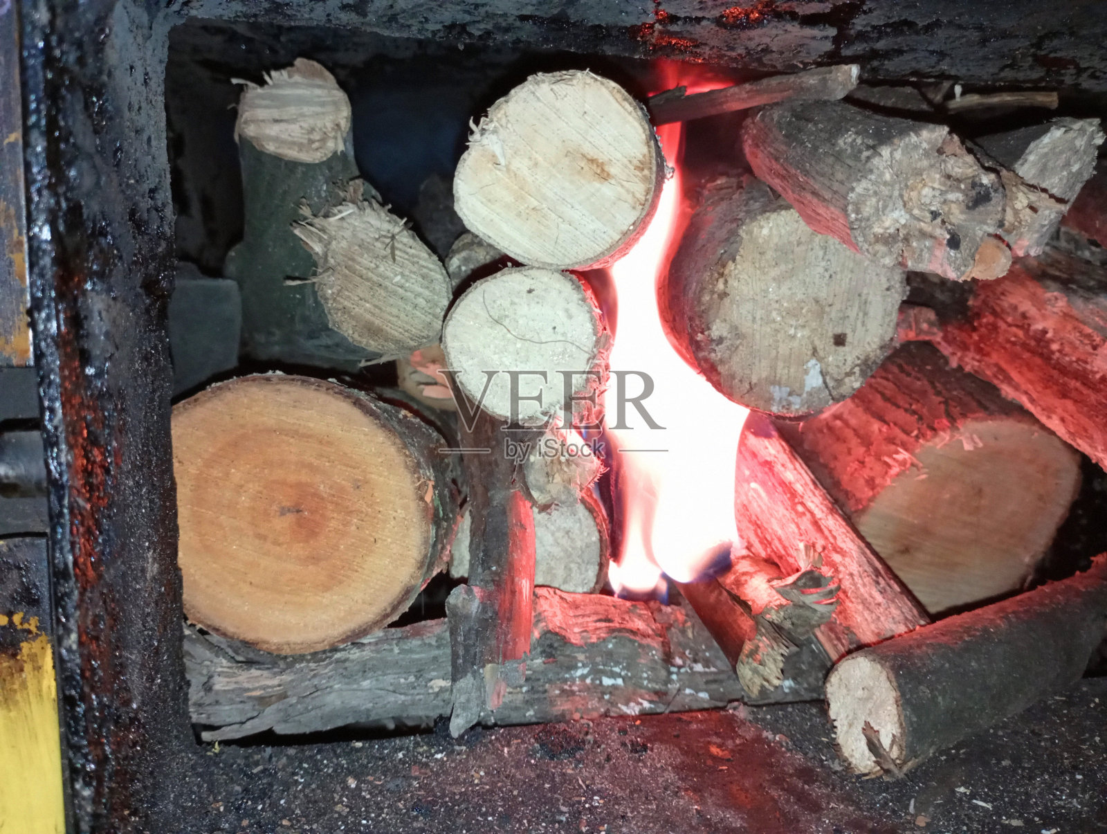 旧锅炉的炉膛里燃烧着柴火。用木柴给房子取暖。在固体燃料锅炉中燃烧木柴。照片摄影图片