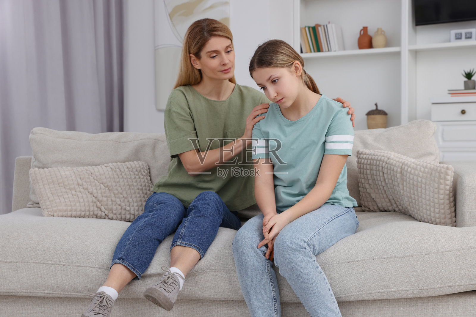 母亲在家里安慰她心烦意乱的十几岁女儿照片摄影图片