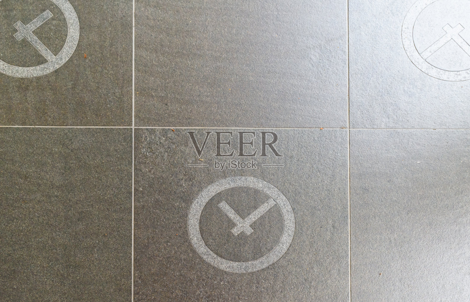 灰色的瓷砖纹理，柔和的光影过渡，中间的小时钟。照片摄影图片