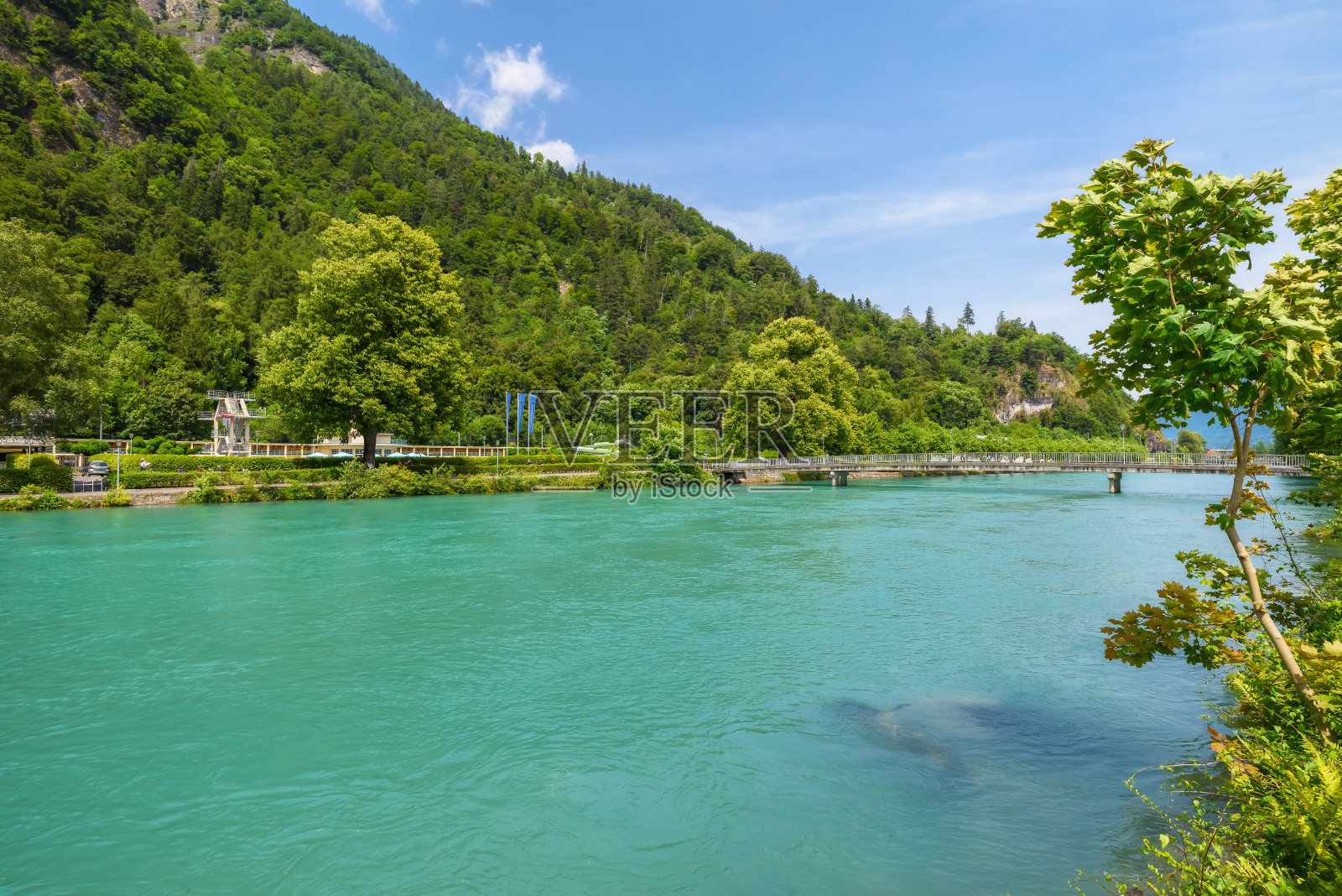 沿着瑞士因特拉肯市哈德山山坡流动的阿勒河。美丽的夏日景观，清澈的水，绿色的树和蓝色的天空。瑞士旅游和地标。全景照片摄影图片