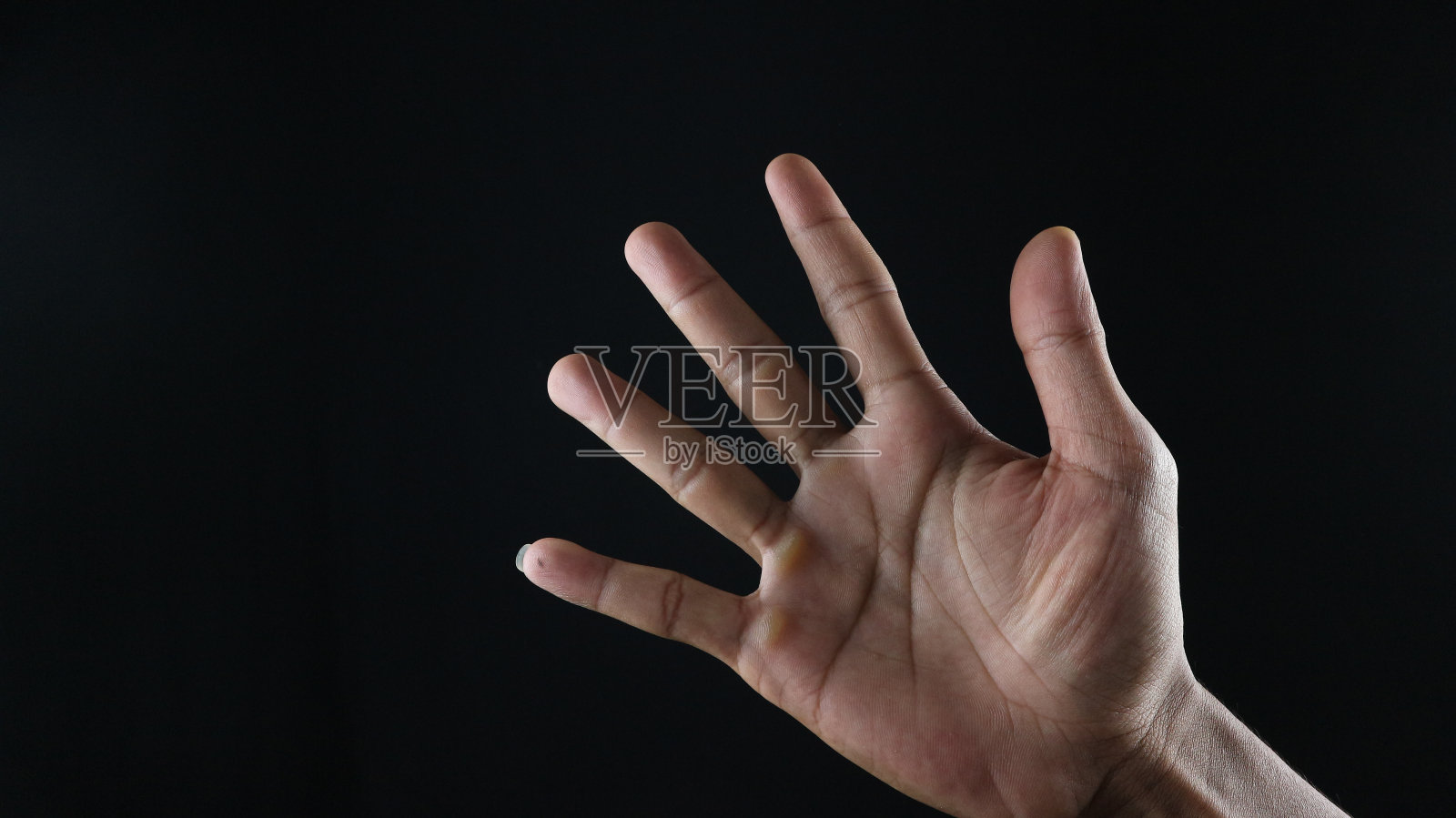 男性手势5号特写被隔离在黑色背景上照片摄影图片