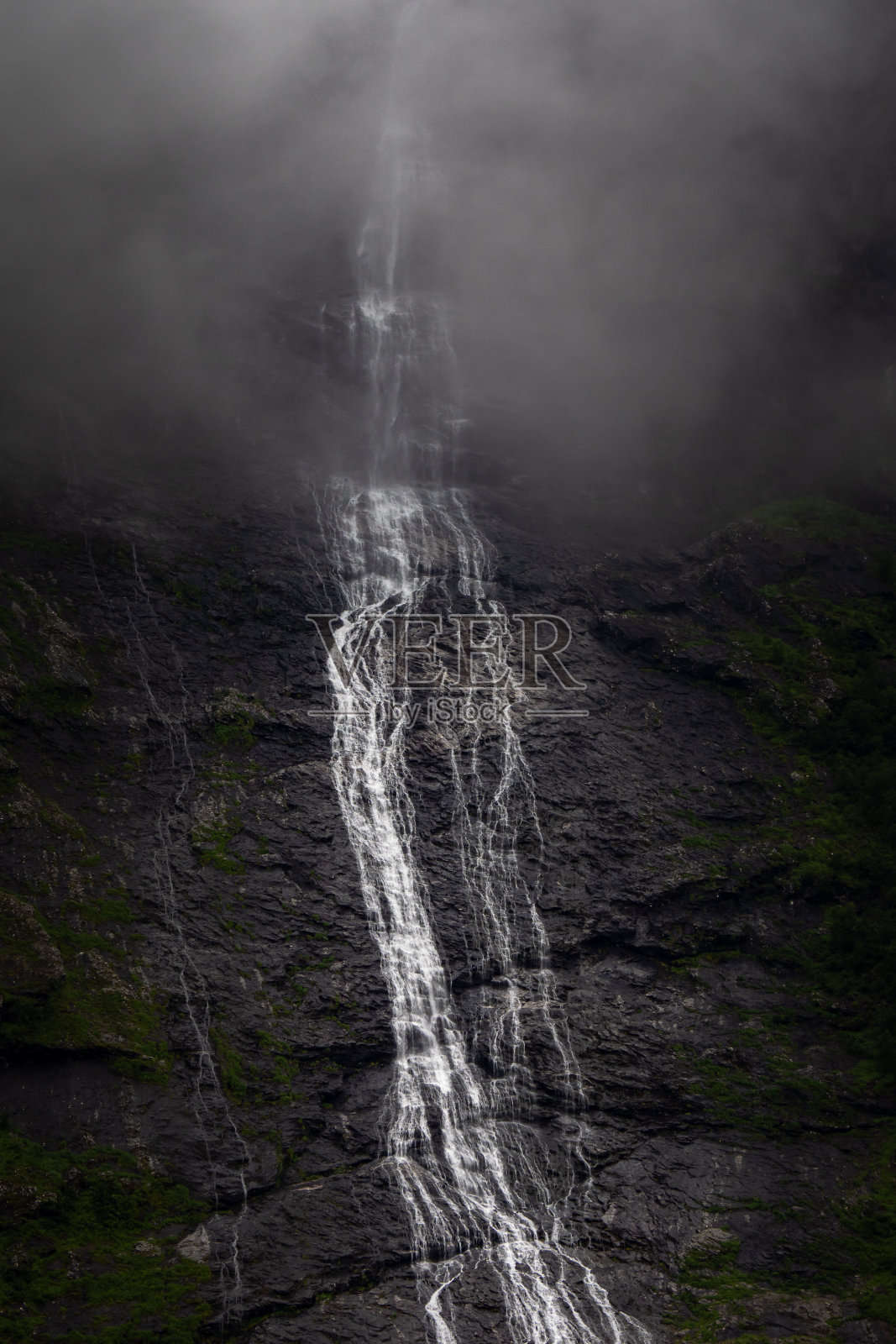 冰川融化的瀑布从山上流下，流入挪威峡湾照片摄影图片