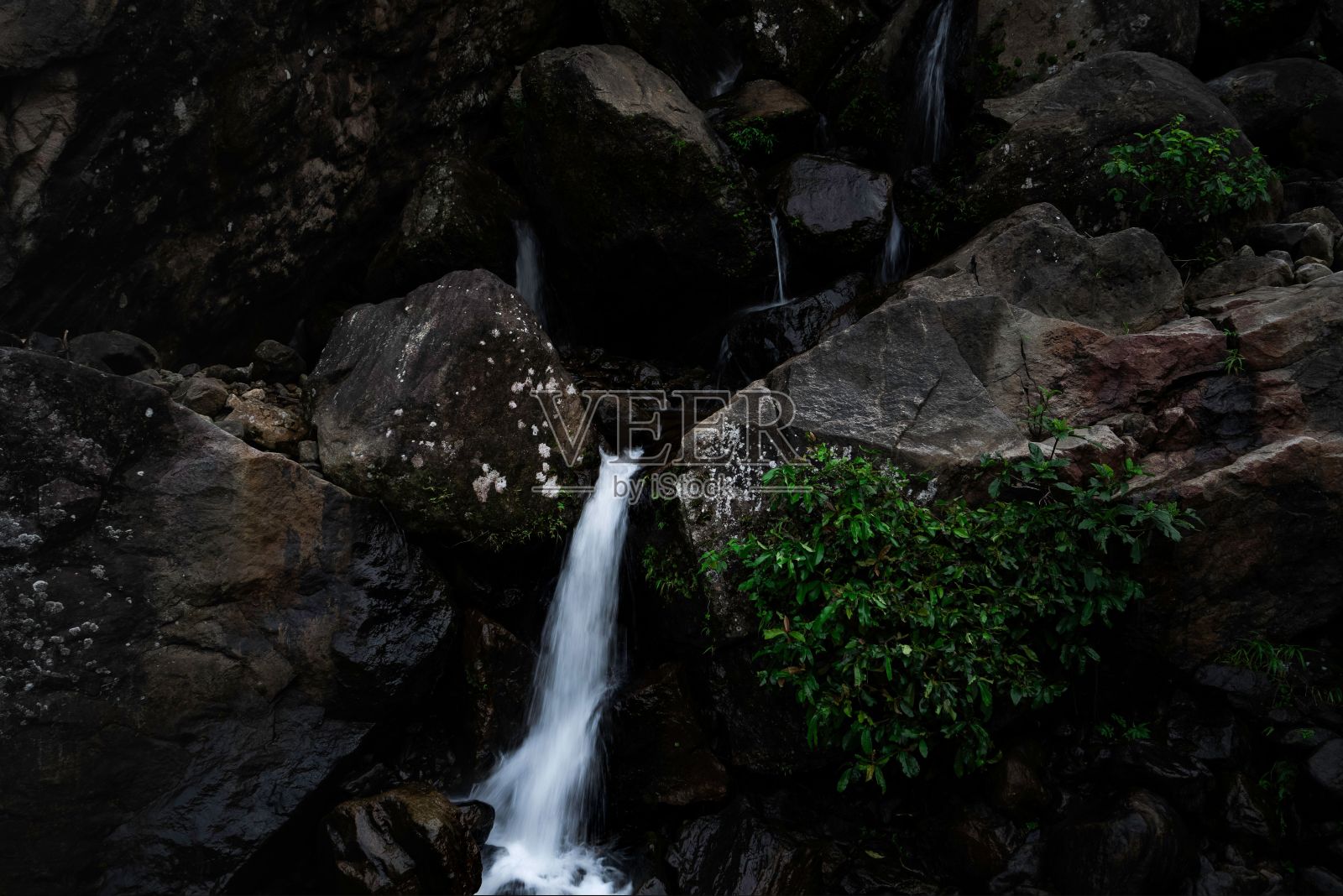 令人惊叹的景观，瀑布从岩石悬崖上倾泻而下，进入平静的游泳池照片摄影图片