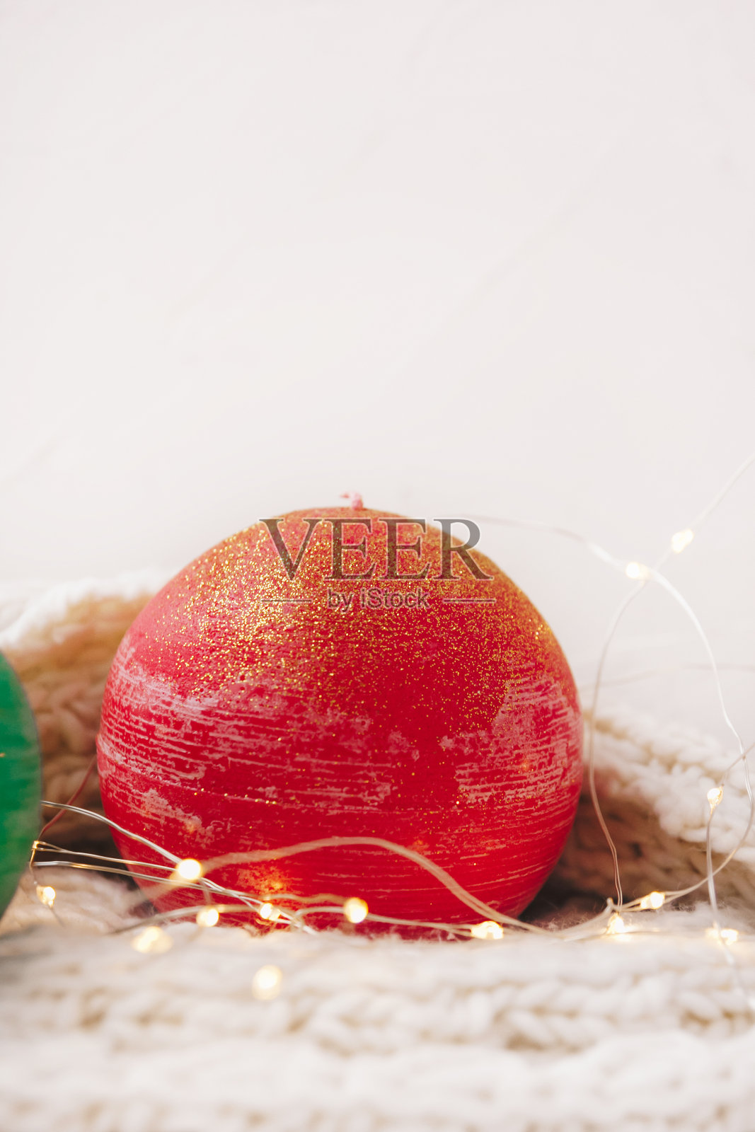 温馨的蜡烛作为圣诞装饰在白色和针织背景球。新年或圣诞假期概念，节日贺卡。照片摄影图片