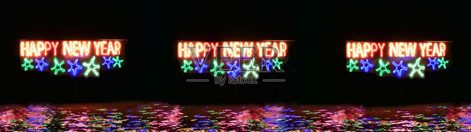 黑色背景的横幅上有三个新年快乐的照明标志。用彩灯和花环做成快乐的寒假。广告水反射。户外招牌。照片摄影图片