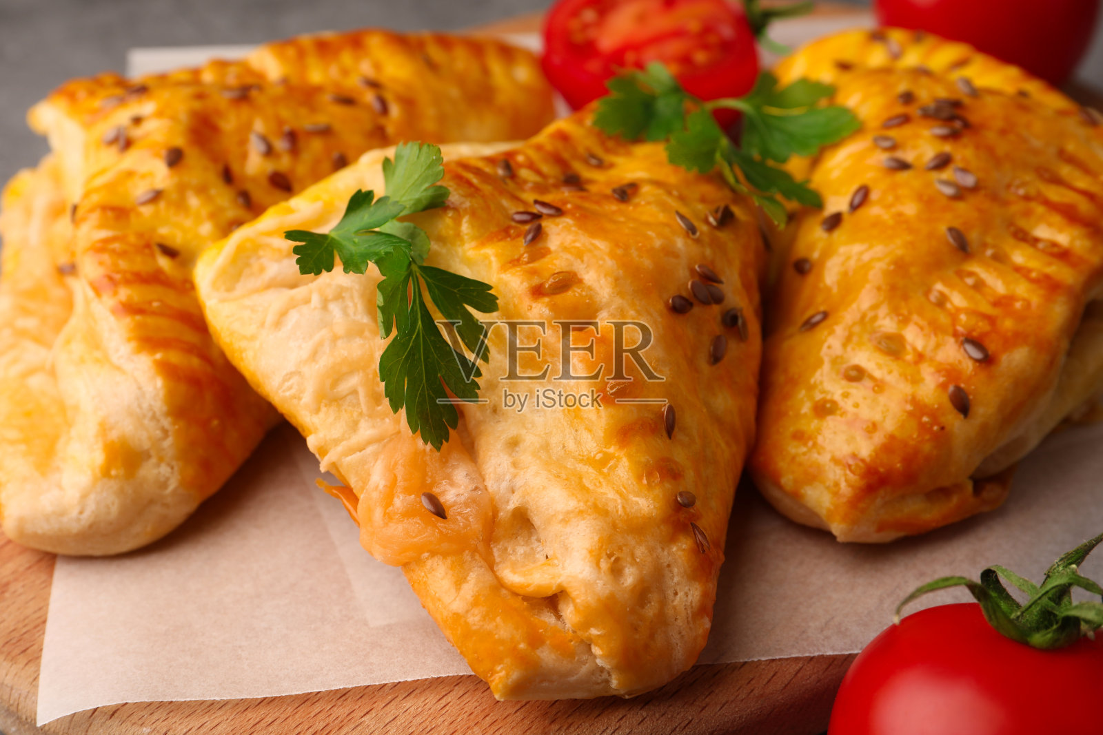 新鲜美味的酥皮与奶酪，西红柿和欧芹放在木板上，特写照片摄影图片