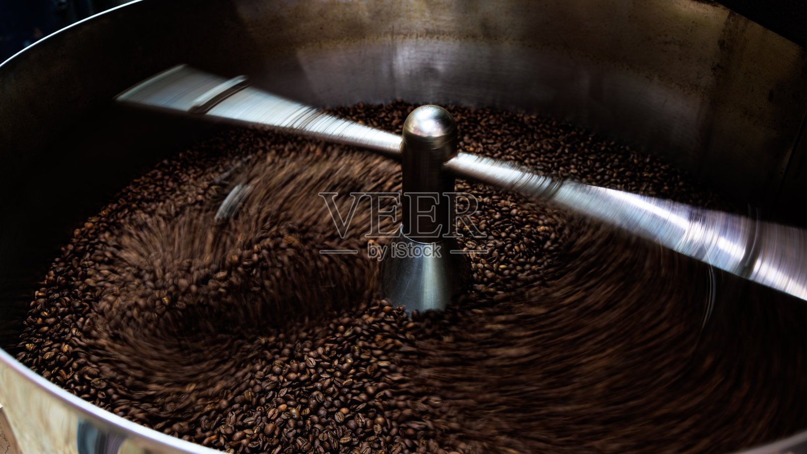 咖啡豆和烘焙纺丝覆盖专业机器，近距离软聚焦，拍摄需要运动和咖啡豆细节概念的低速照片;照片摄影图片