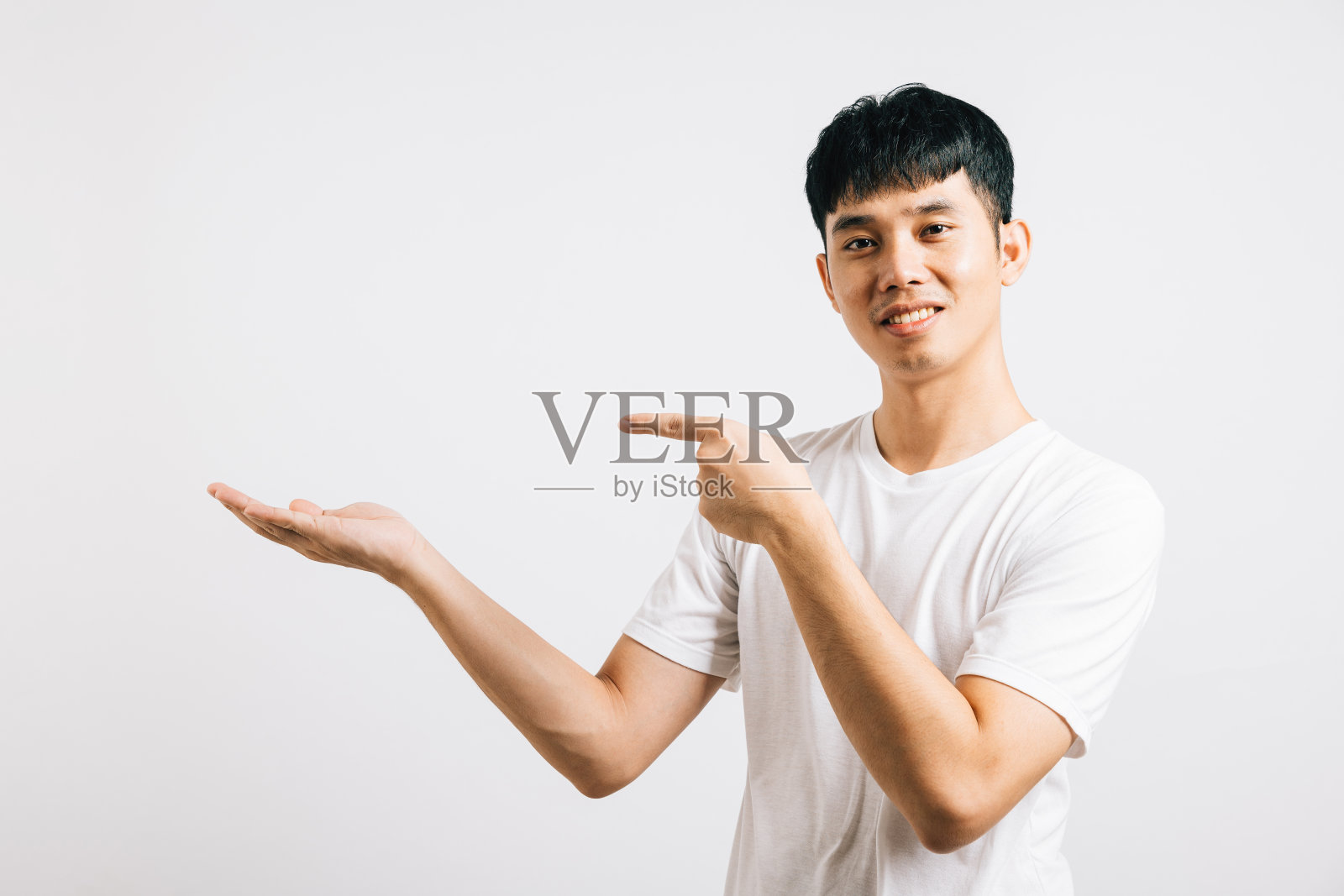 微笑的亚洲男人用自信的手指引导人们的注意力照片摄影图片