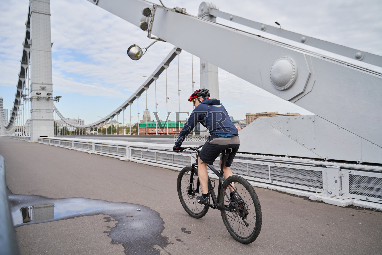 一个人骑着自行车过桥。照片摄影图片