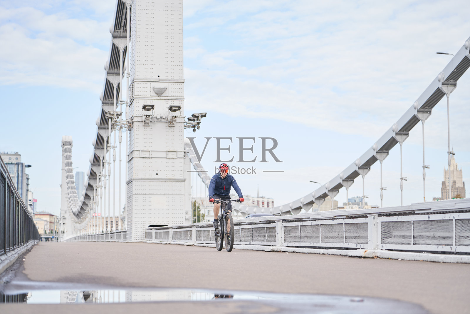 一个人骑着自行车过桥。照片摄影图片