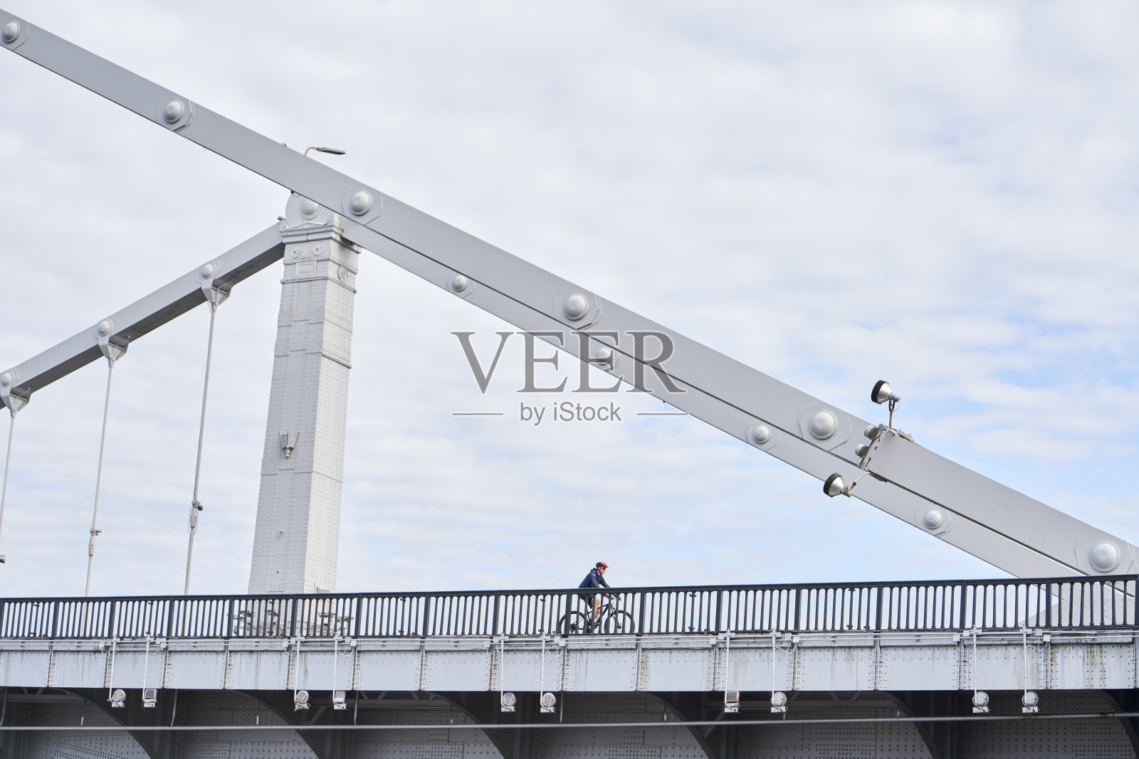 一个人骑着自行车过桥。照片摄影图片