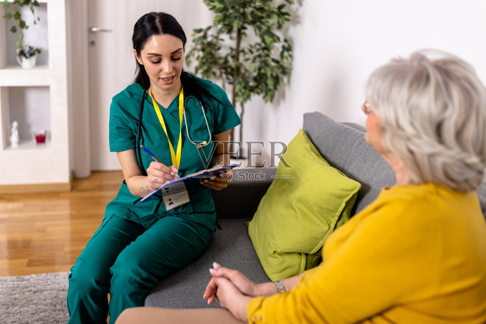 年轻的护理人员利用医学专业知识诊断老年妇女的健康状况照片摄影图片