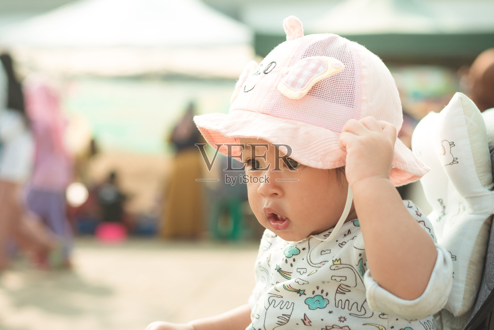 一个可爱的亚洲女婴头戴一顶帽子在户外照片摄影图片