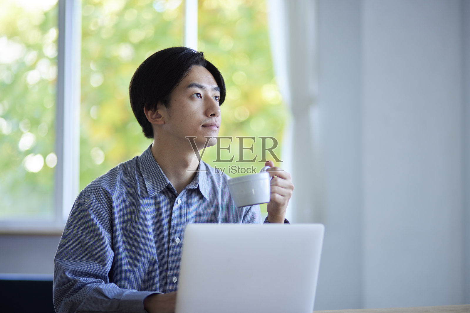 在客厅学习的日本男大学生照片摄影图片