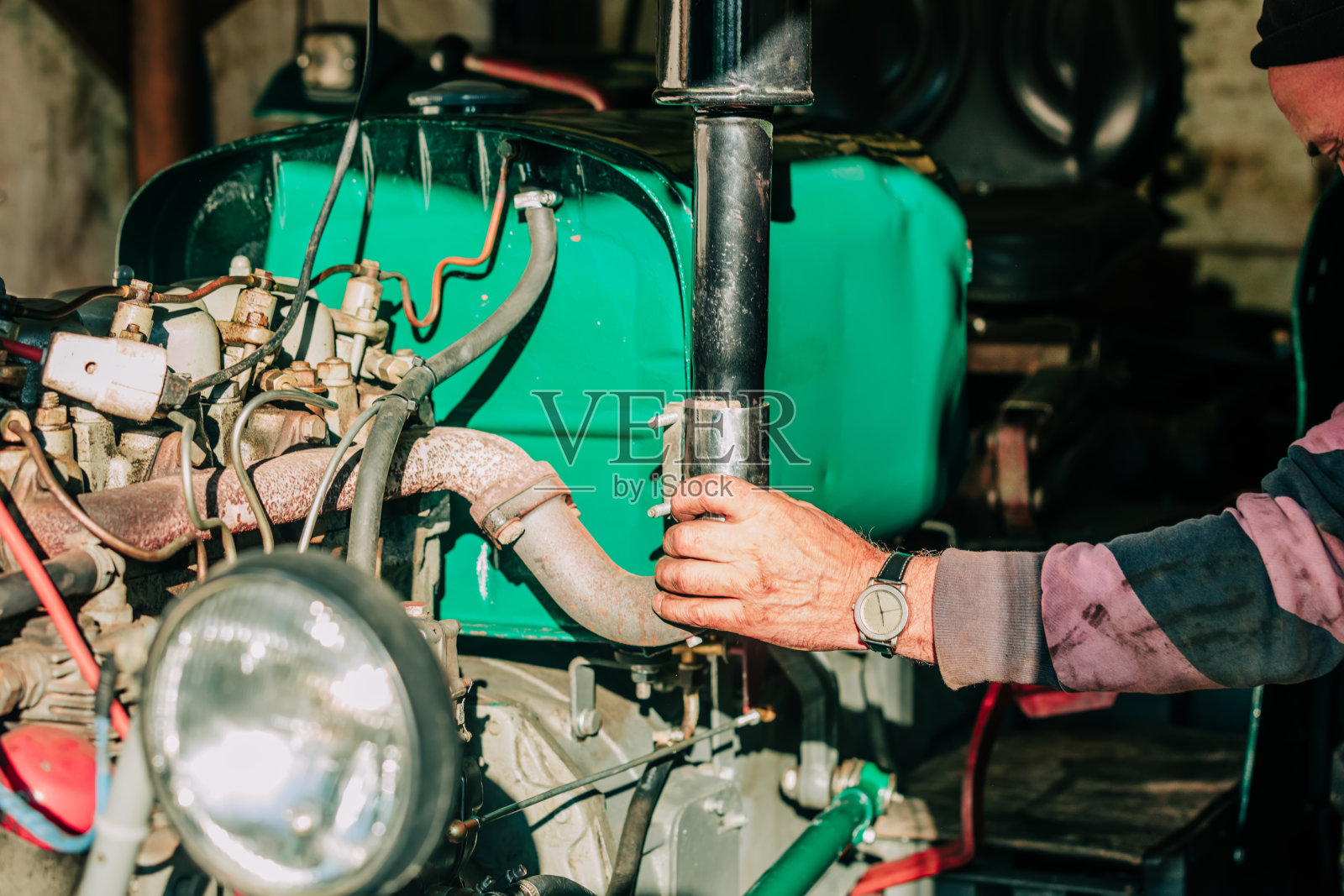 波兰，老人试图修理老式拖拉机照片摄影图片