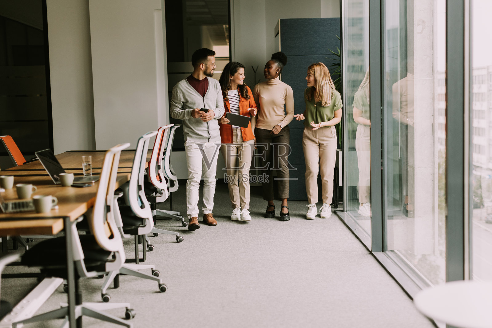 年轻的多民族创业团队走在现代化的办公室里照片摄影图片