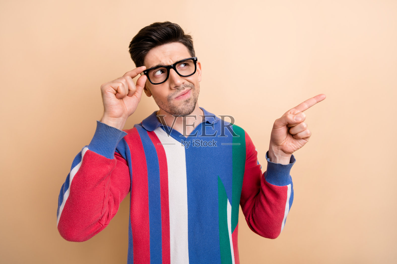 照片中的年轻人思考时，指导他的手指空白的空间信息猜测发生了什么孤立的米色背景照片摄影图片