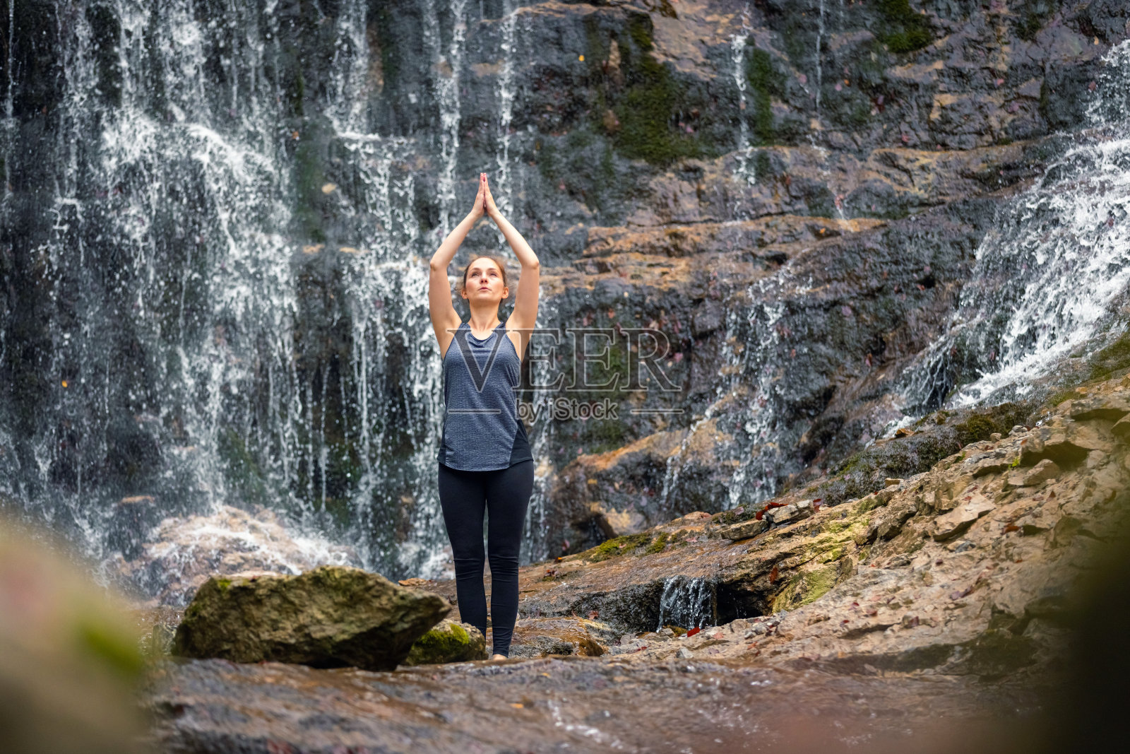 女人在瀑布边沉思，与大自然联系照片摄影图片
