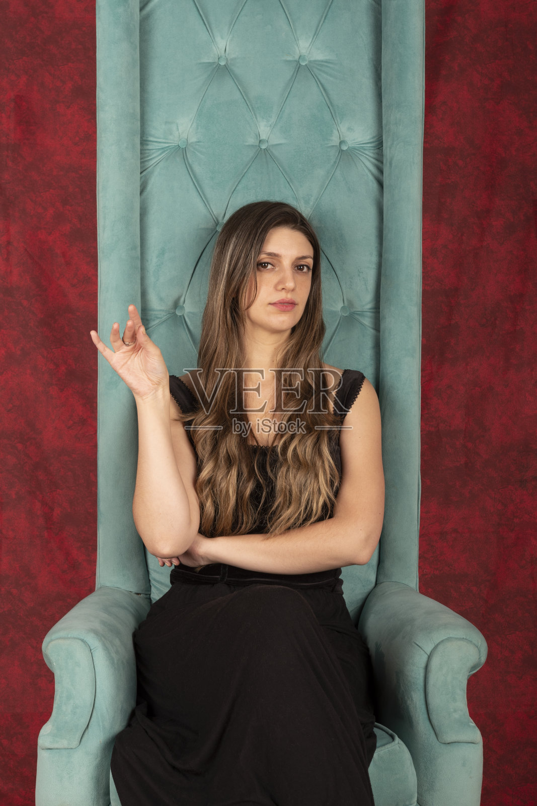 一个金发女人坐在一张女王式的扶手椅上，一副骄傲的表情照片摄影图片