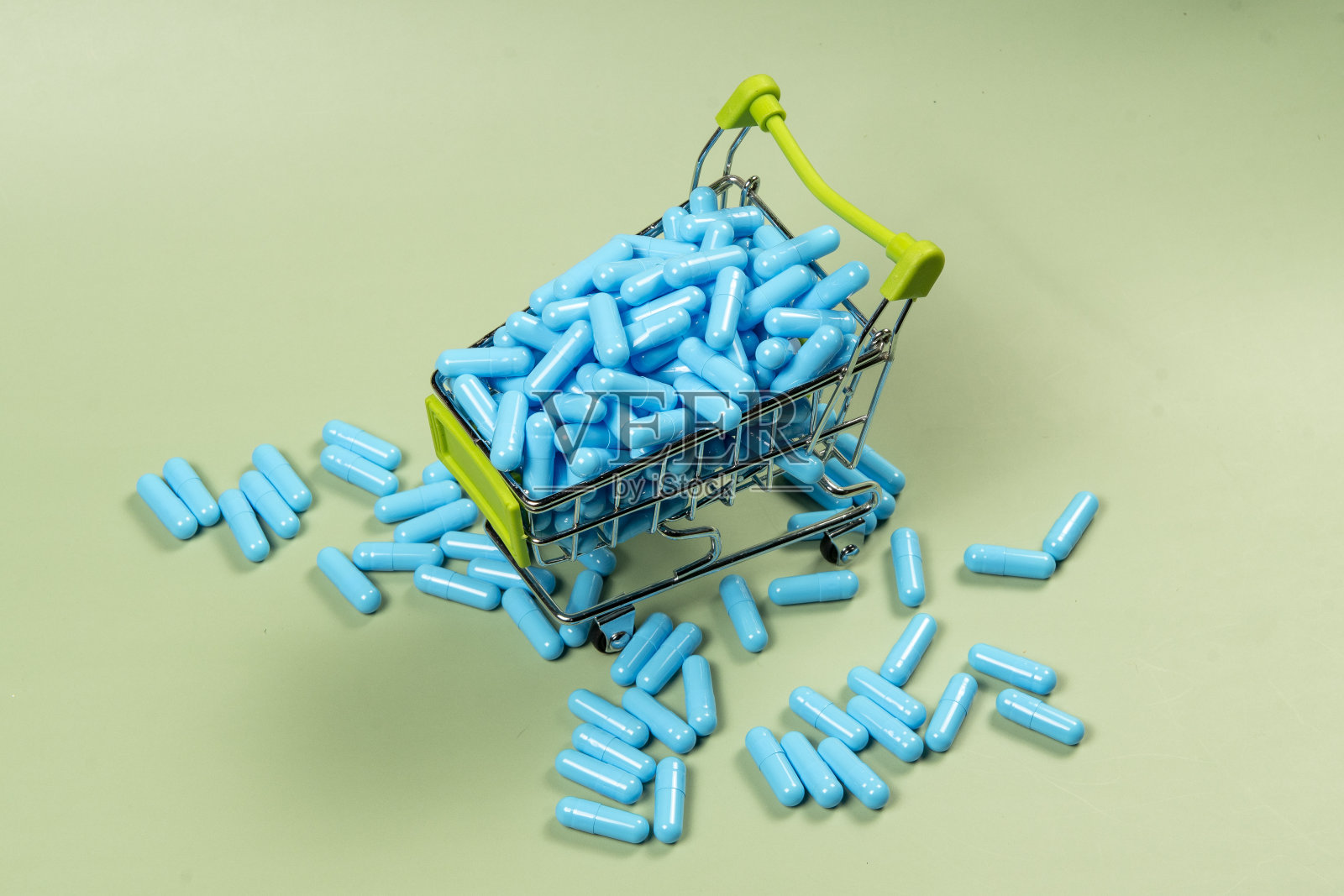 微型购物车里的蓝色药胶囊照片摄影图片
