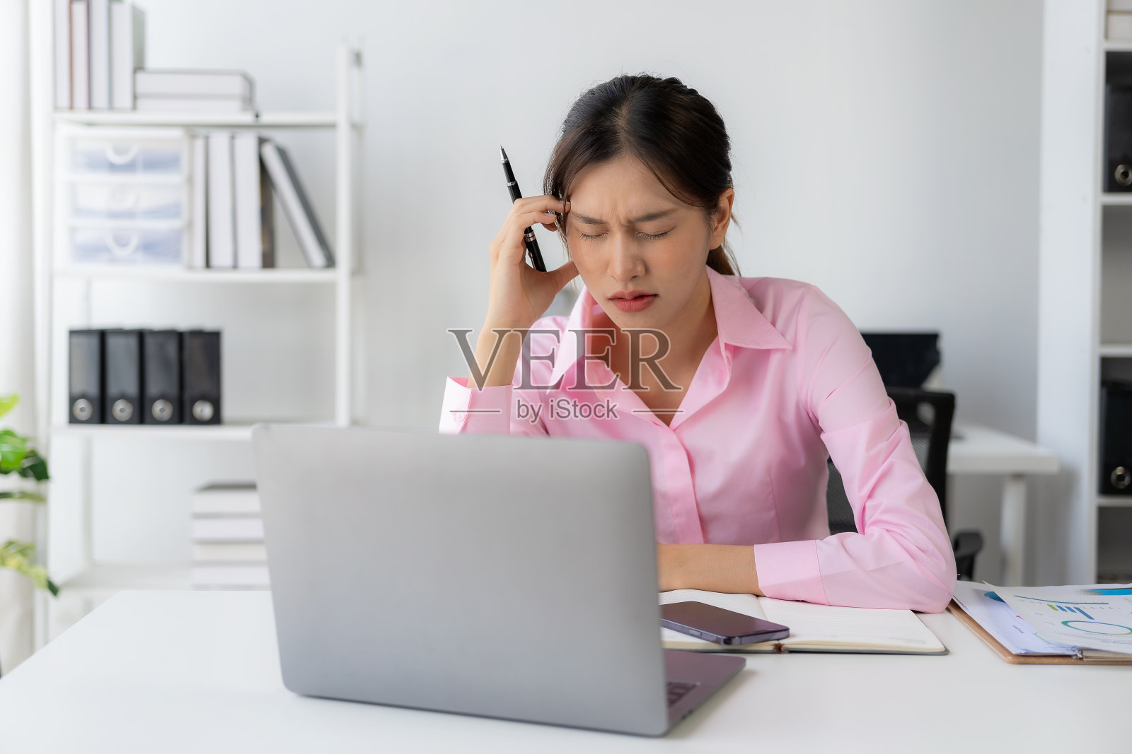 工作中感到压力的年轻亚洲女职员照片摄影图片