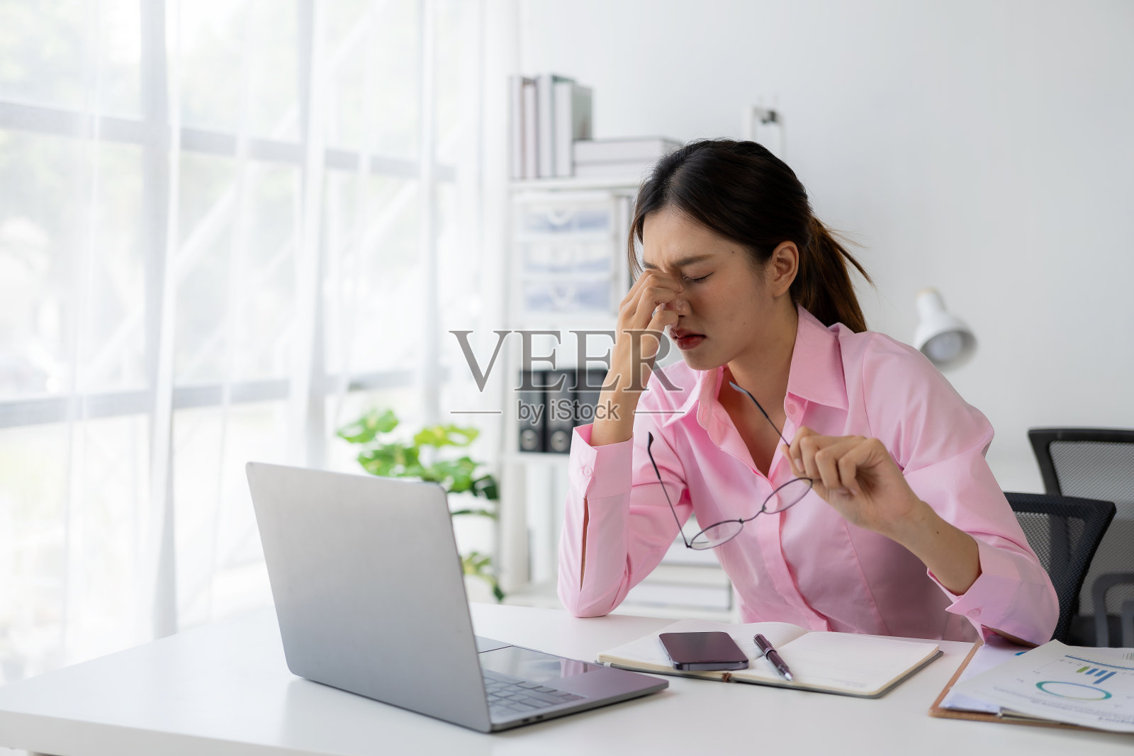 工作中感到压力的年轻亚洲女职员照片摄影图片