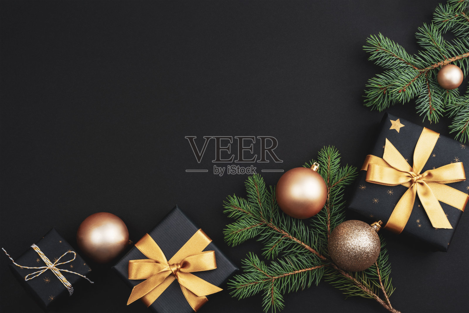 黑色背景的金色圣诞球、礼物和装饰品。节日的平淡。俯视图，复制空间照片摄影图片