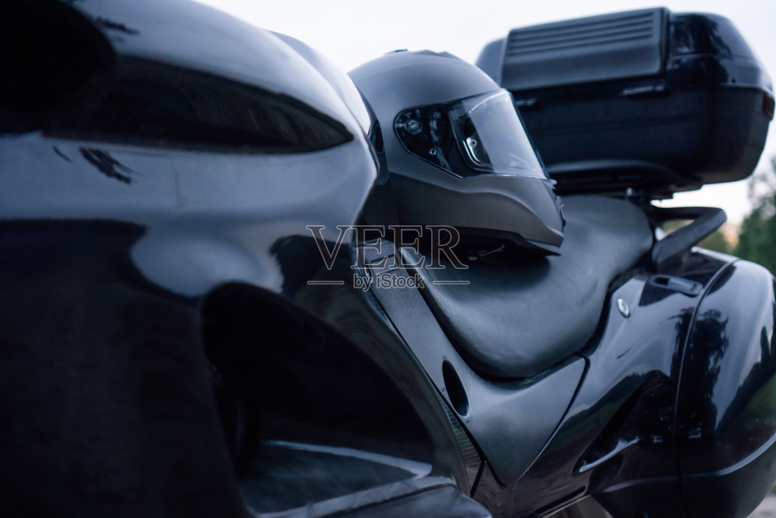 黑色新摩托车的特写，座位上有头盔，在大自然中。旅游和旅行。照片摄影图片