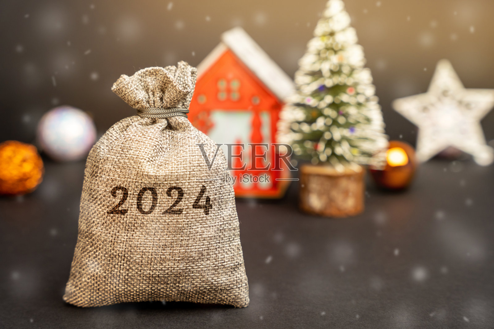 2024年的钱袋，圣诞树和红房子。圣诞快乐，新年快乐!圣诞节的概念。攒钱，做预算。商业和金融。贷款、存款、信贷。照片摄影图片