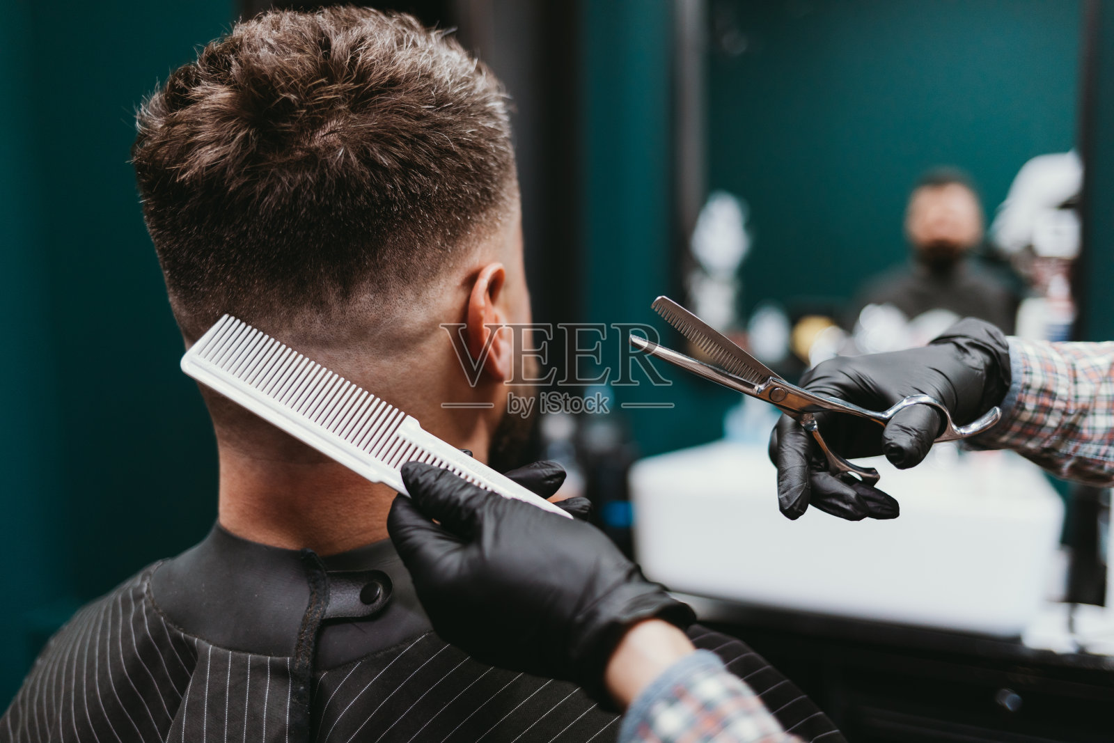 理发店里的男人，特写理发师正在给大胡子男人理发照片摄影图片