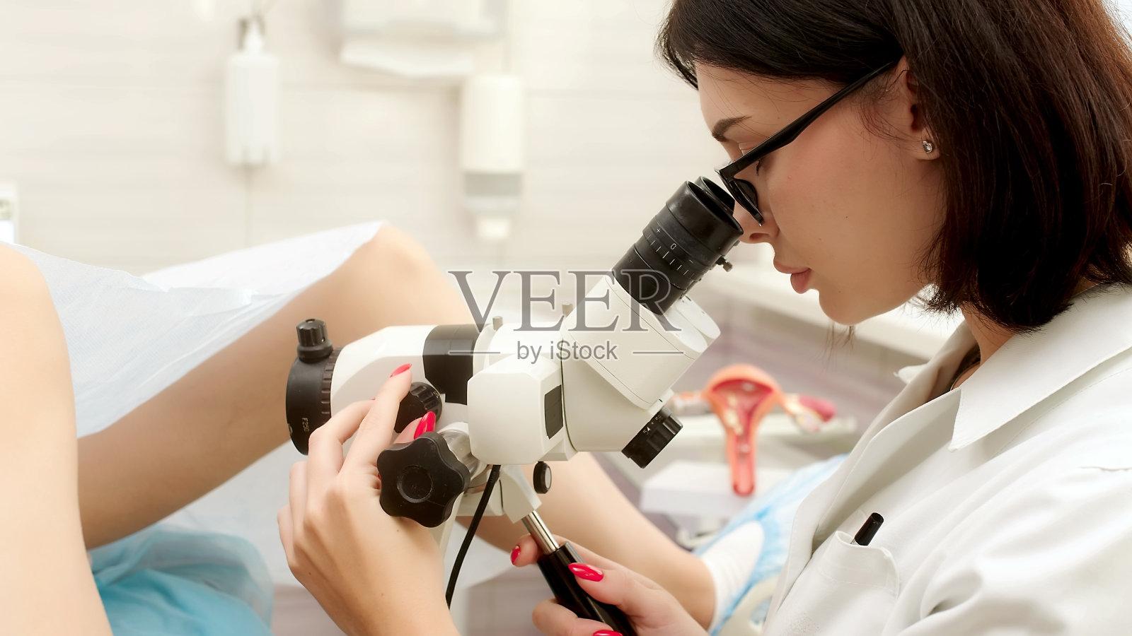 妇科办公室的病人和医生在做阴道镜检查。妇科医生通过数码阴道镜观察女性疾病。医学测试。照片摄影图片