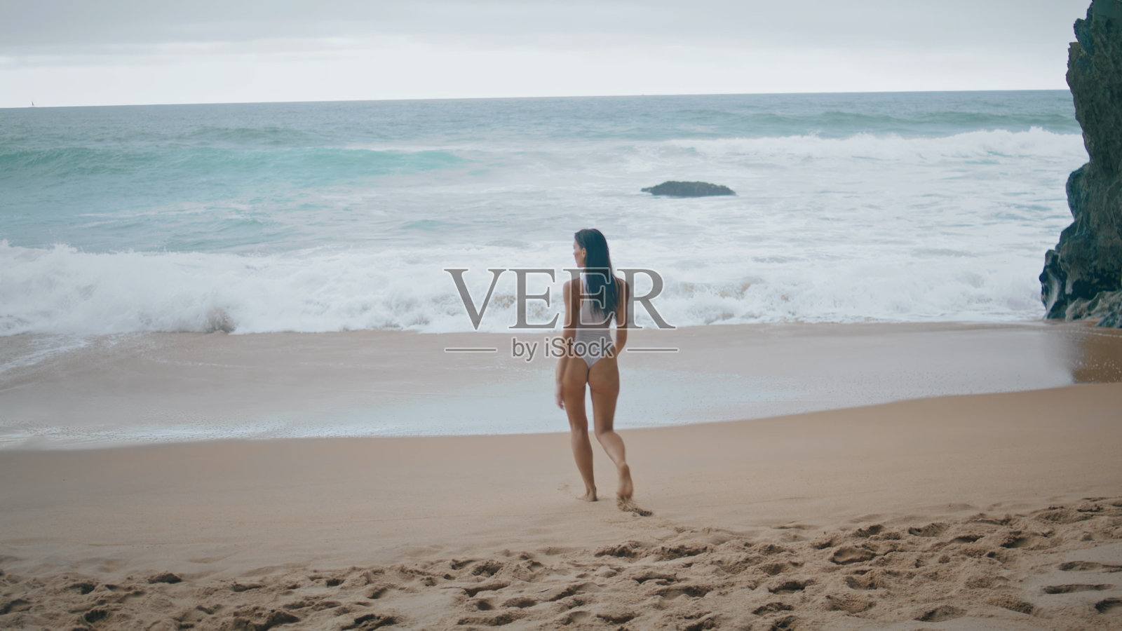 性感的女孩在沙滩上穿着白色的泳装。女人喜欢海洋照片摄影图片