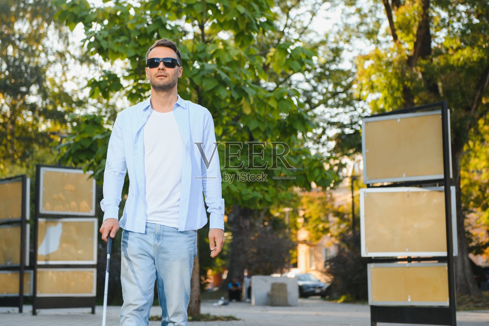 盲人。拄着拐杖的视障男子，照片摄影图片