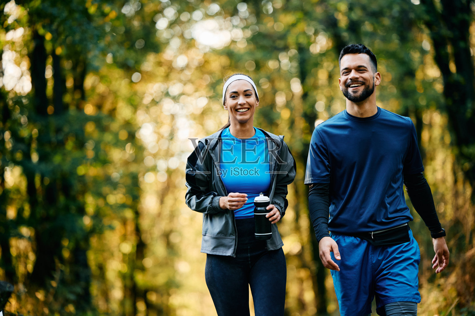 一对幸福的运动员在公园散步。照片摄影图片