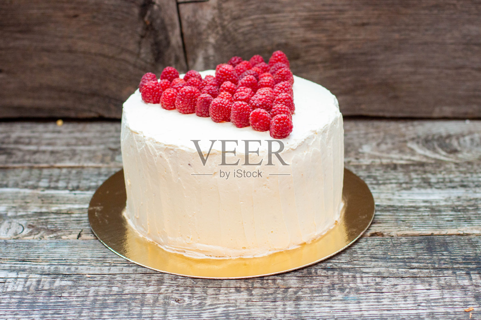 优雅的白色蛋糕覆盆子心为圣情人节，母亲节，或生日，用新鲜的浆果糖在木制背景装饰照片摄影图片