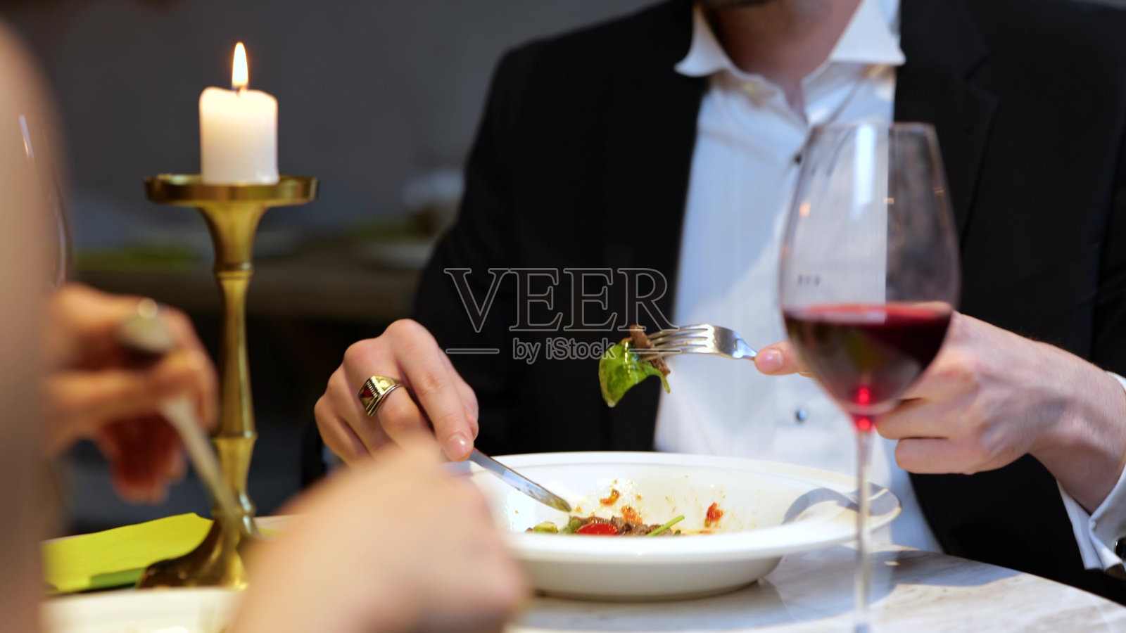 时尚的年轻人在餐厅与女友约会时享用美味的沙拉。生活方式，爱情，关系概念。慢动作照片摄影图片