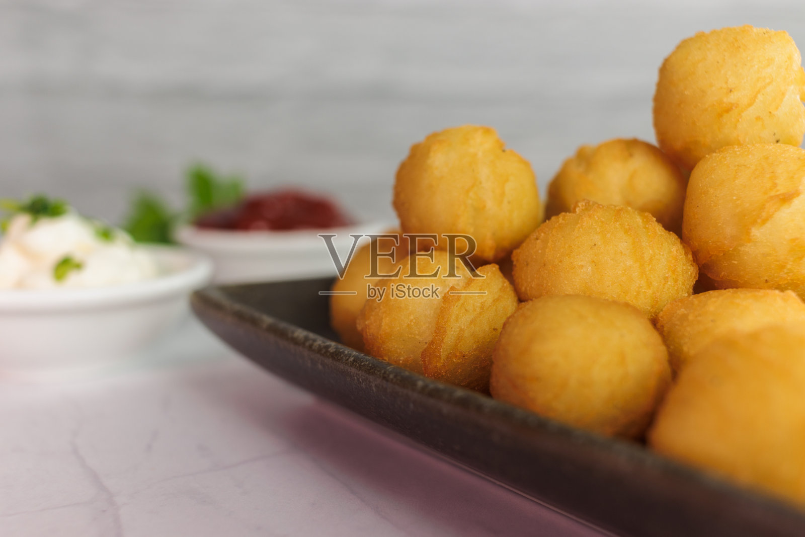 公爵夫人土豆，自制，典型的智利，欧芹，矩形盘子，容器，番茄酱，蛋黄酱，白色背景，复制空间，特写，垂直。典型智利食物的概念照片摄影图片