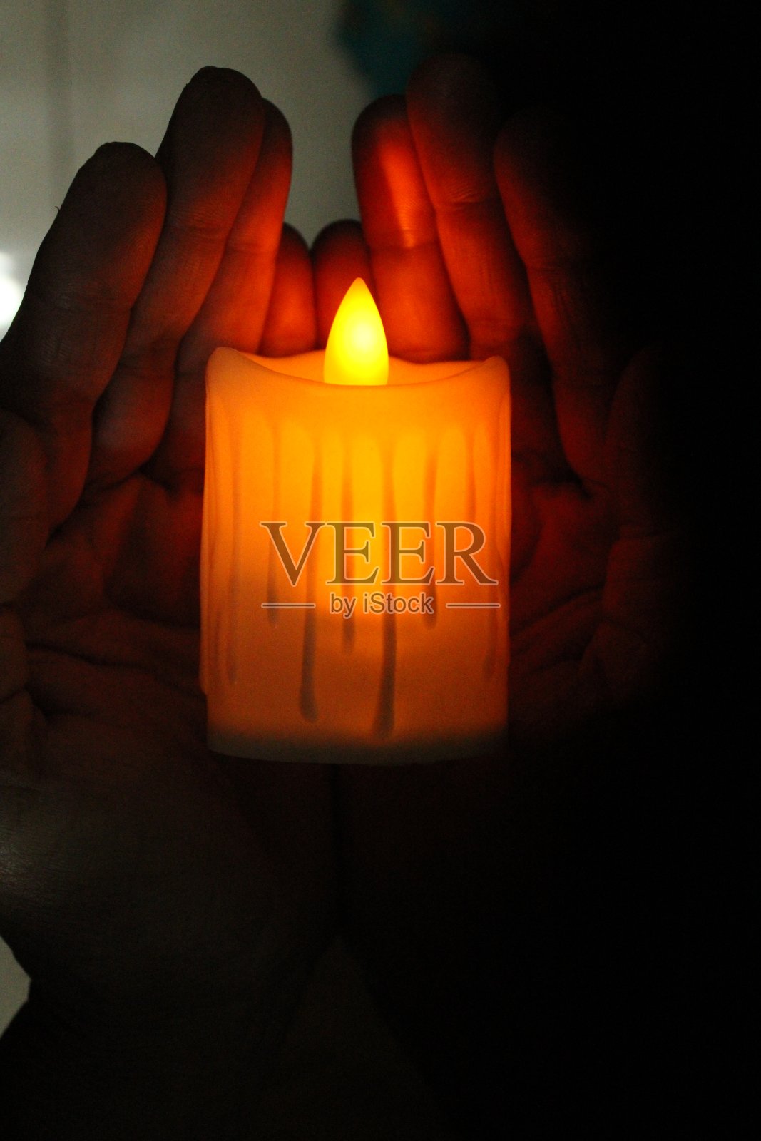 手里拿着烛光。照片摄影图片