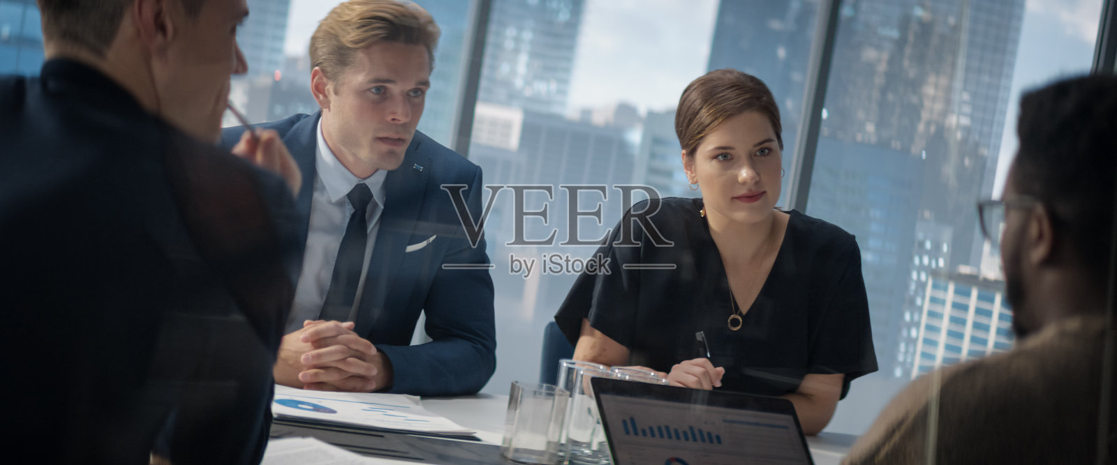 不同的同事在大城市的办公室会议室交谈，讨论业务战略。多民族专家头脑风暴，使用笔记本电脑，从事高科技项目。照片摄影图片