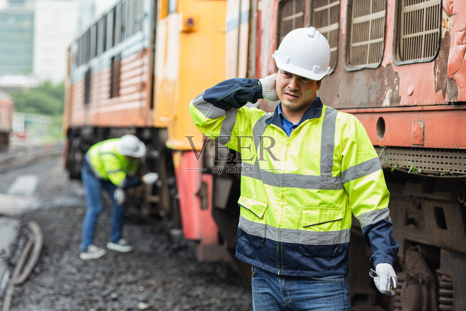 工程师工人因炎热的天气在户外工作而疲惫不堪，与老柴油列车的男服务人员在一起照片摄影图片