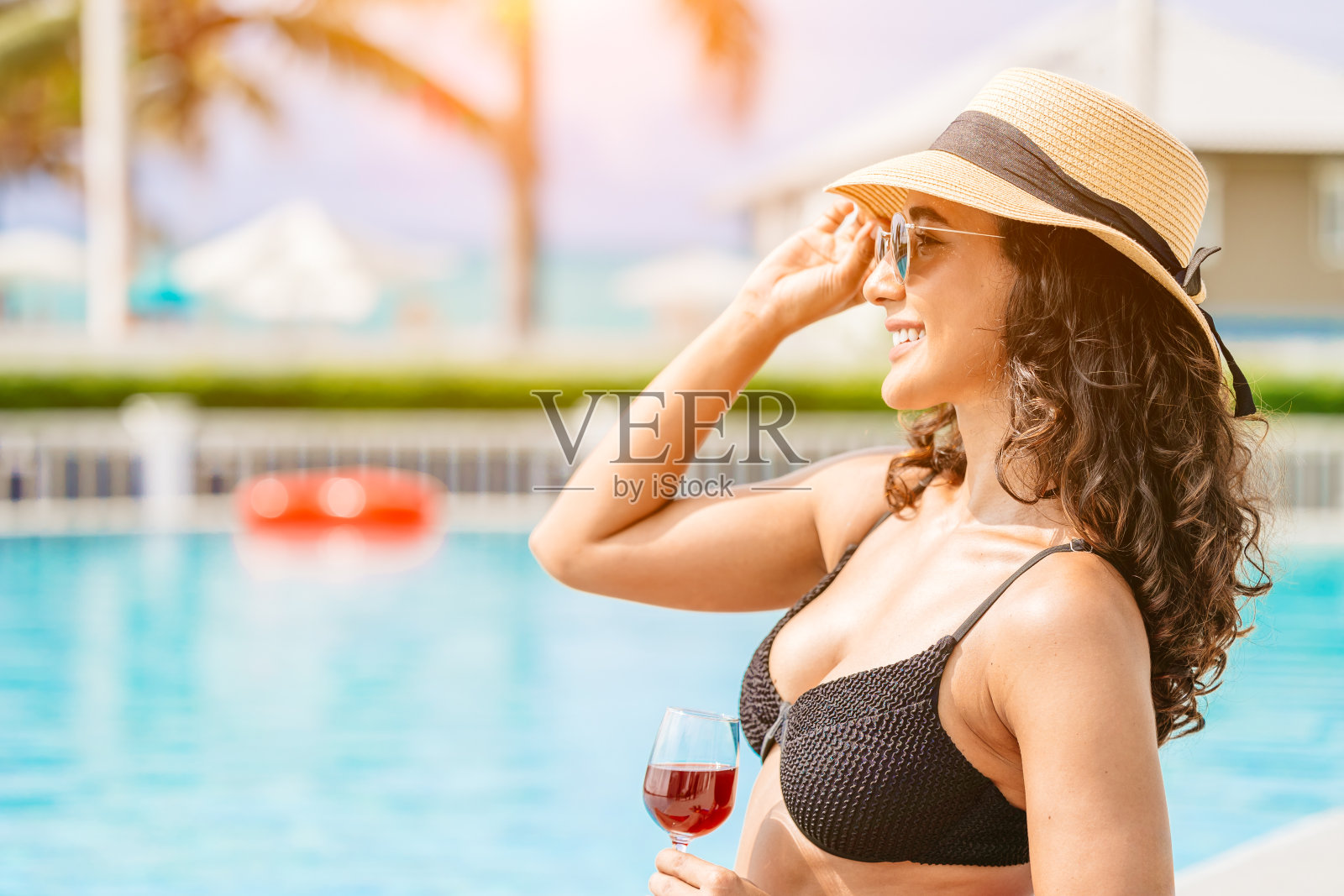 美女享受在游泳池放松，暑假旅游度假。近距离的旅游女孩享受在豪华的海滩度假胜地寒冷的阳光明媚的一天。照片摄影图片