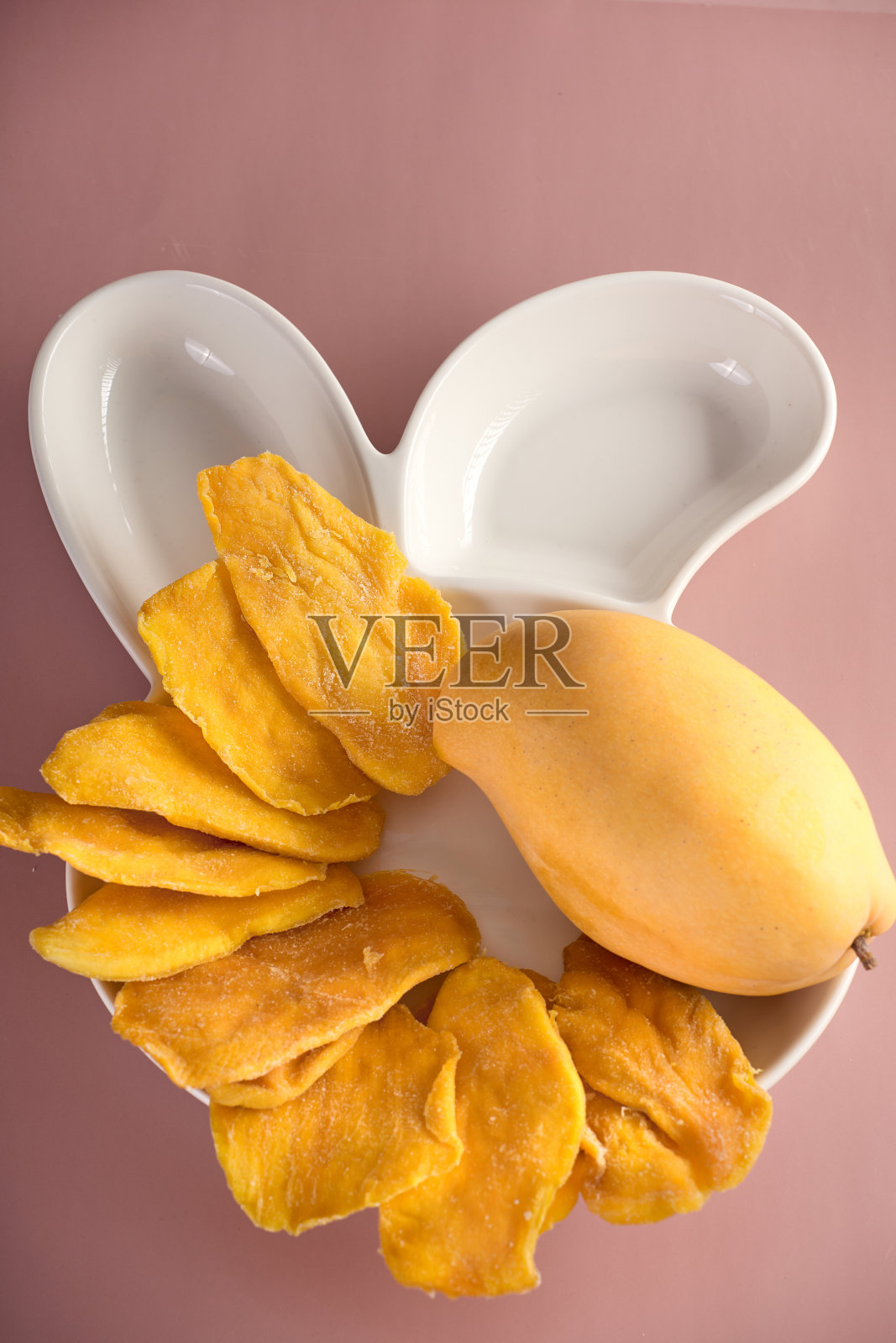 在白色拼盘上提供美味健康的芒果蜜饯照片摄影图片